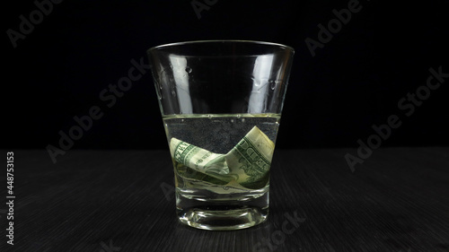 Soak US Dollars in a glass filled with isopropyl alcohol and water. The science concept of burning money without damage