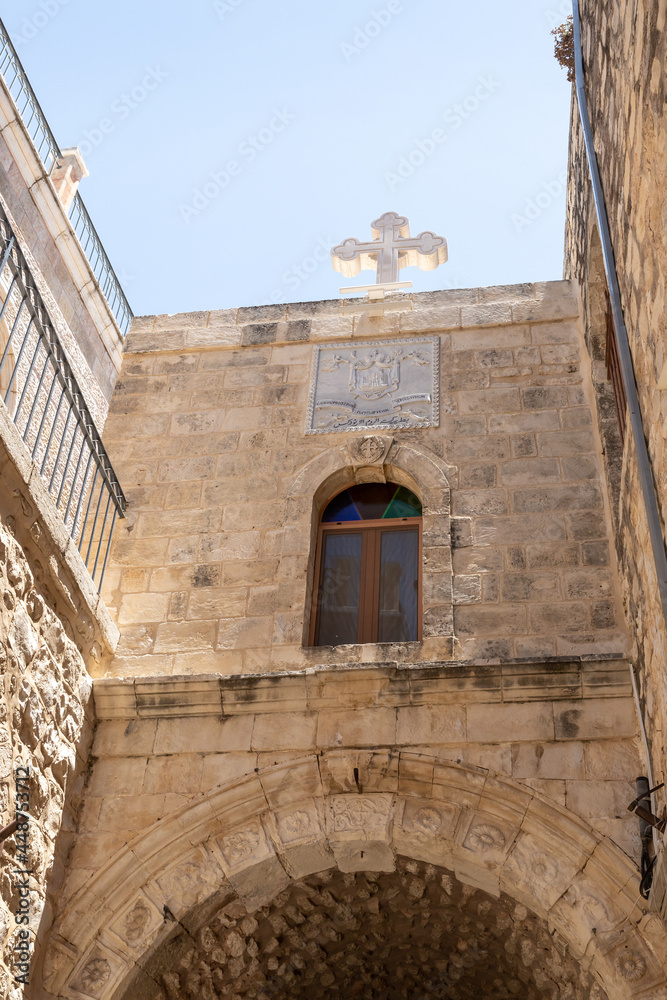 Large  white stone cross on the roof of the building on the Greek Patriarchate Street in Christian quarters in the old city of Jerusalem, Israel