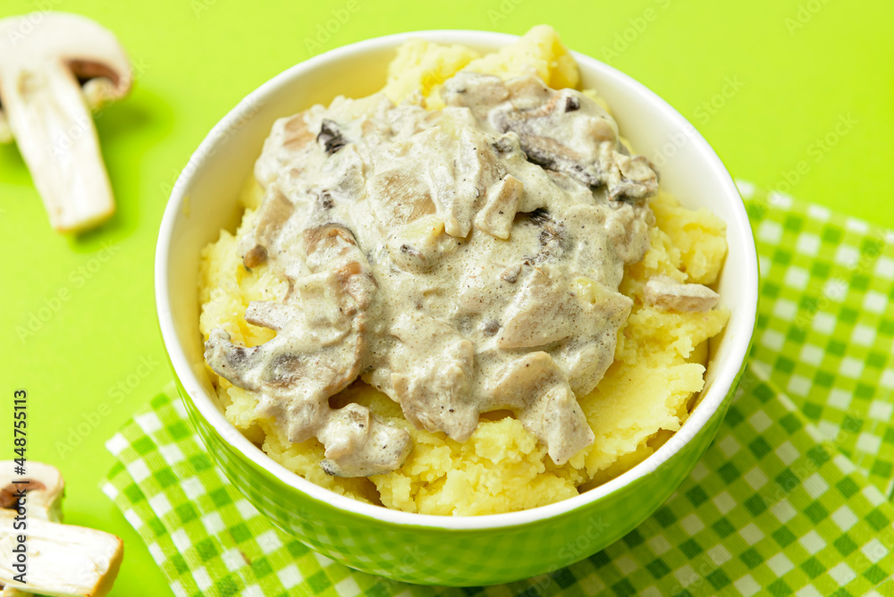 Bowl with tasty mashed potatoes and mushrooms on color background Bowl with tasty mashed potatoes and mushrooms on color background