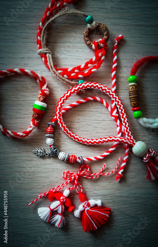 Bulgarian traditional spring decor martenitsa bracelets, wooden background. Baba Marta holiday, backdrop.