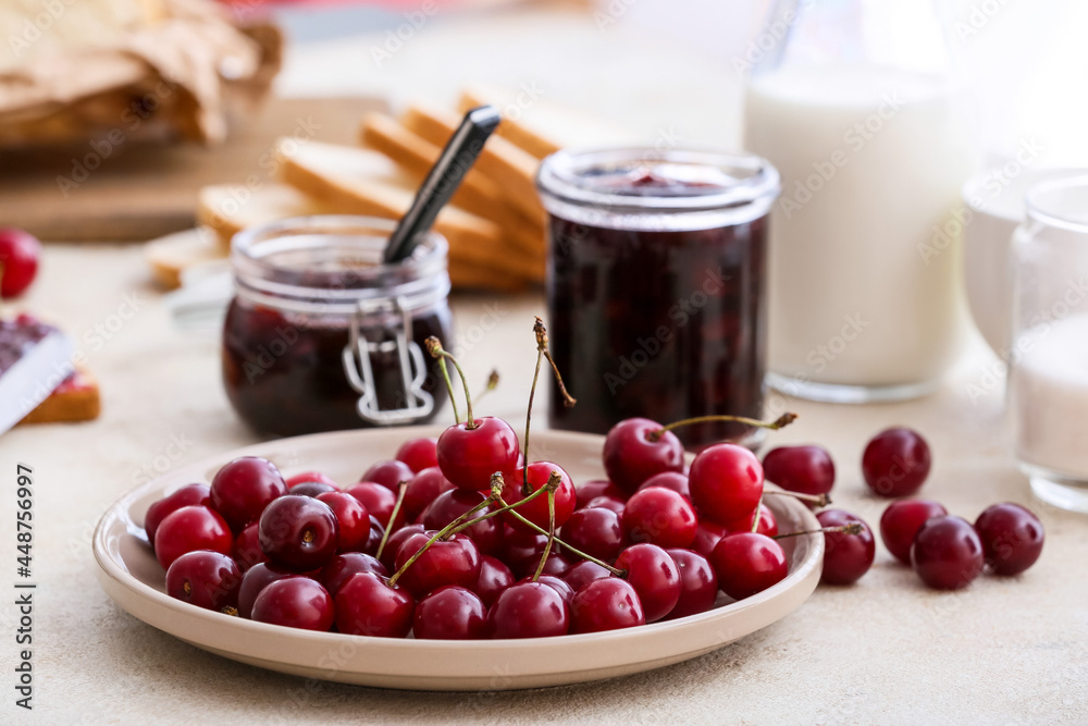 Ripe cherry and tasty jam on table Ripe cherry and tasty jam on table