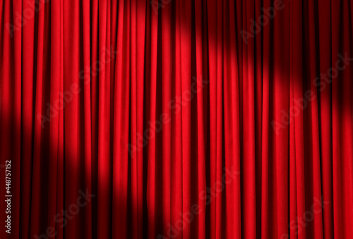 Spotlight illuminating closed red stage curtains. Start of performance
