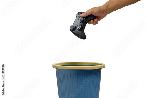 Gaming joystick is thrown into trash.Concept of refusal for computer games. photo