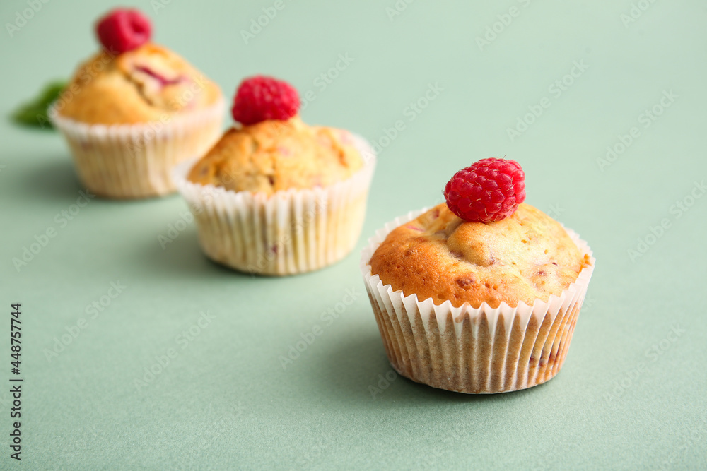 Tasty raspberry muffins on color background, closeup Tasty raspberry muffins on color background, closeup
