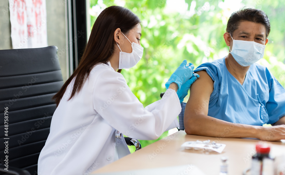Fototapeta premium Asian young doctor syringe injection to the elder patient. health ideas concept. Problem talk at medical checkup visit with wheelchair .