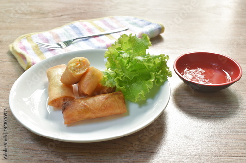 deep fried spring roll stuffed glass noodles with lettuce dipping sweet chili sauce on dish
