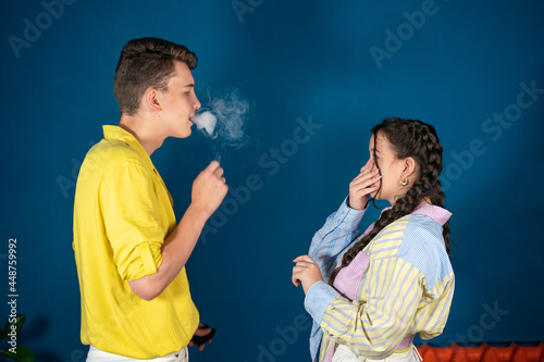Passive smoking concept. Teen girl pinch her nose because toxic fumes from car,bad smell,air pollution,dust allergies or sinus infection,female teenage rubbing nose suffer from allergic in city