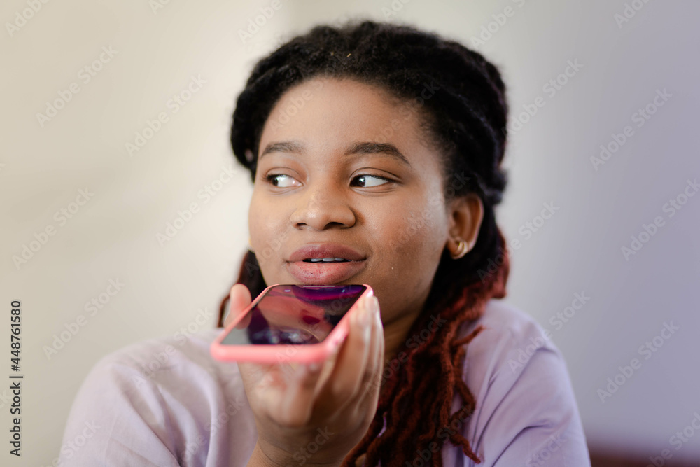 Portrait of a Young Afro woman who sits in a cafe with a smartphone and talks Portrait of a Young Afro woman who sits in a cafe with a smartphone and talks
