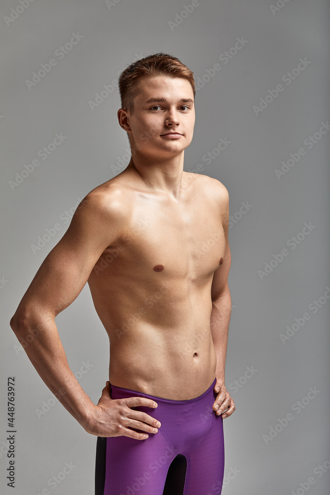 Young swimmer in excellent physical shape, on a gray background with copy space, call for sports, advertising banner