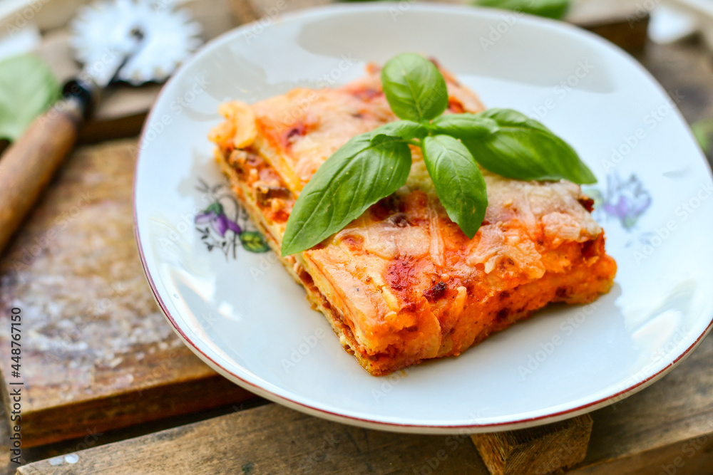   Delicious Home made keto diet  Lasagna bolognese  with  Lupin Flour, minced meat,tomato sauce and spinach  on a wooden rustic  background.Home made low carb italian meal