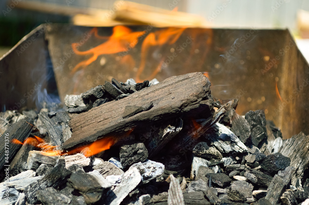 close-up - a flaming fire in an iron barbecue, charcoal, smoke and fire close-up - a flaming fire in an iron barbecue, charcoal, smoke and fire