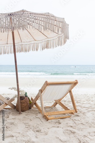Chair with umbrella on white sand beach near the sea. Summer holiday concept.