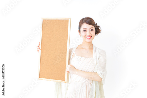 コルクボードを持つドレス姿の女性
