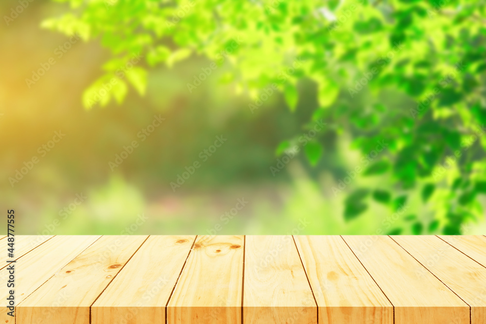 Wood floor with blurred trees of nature park background and summer season, product display montage Wood floor with blurred trees of nature park background and summer season, product display montage