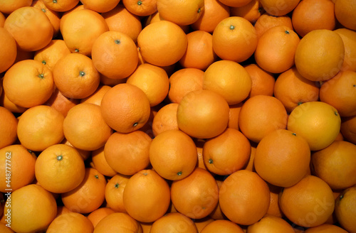Image of orange fruit on a market stall. A pile of fresh tangerines waiting to be sold in the supermarket. Used for background, fruit wallpaper.