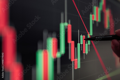 Crop trader working with financial charts on computer screen photo