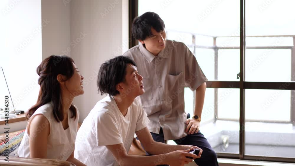 おうちでスポーツを観戦する若い男女 おうちでスポーツを観戦する若い男女
