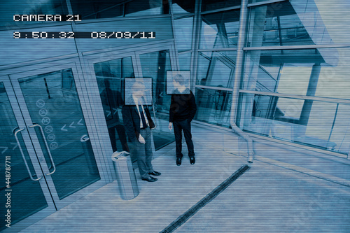 Security camera image of men standing outside entrance of public building