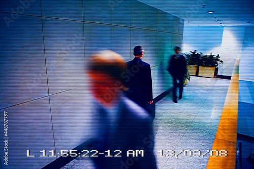 Security camera image of men walking in office corridor