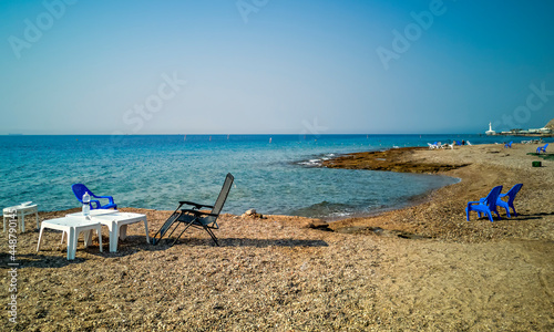 Sandy and sunny beach of the Red Sea with chairs for happy vacation and relaxation after travel restrictions due to epidemic illness , Red Sea, Middle East