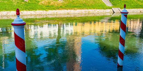 view of canal with red and white pole in Dolo, Venice, Italy