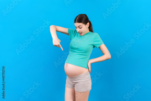 Young surprise or shocked woman pregnant isolated colored background. expression female © sosiukin