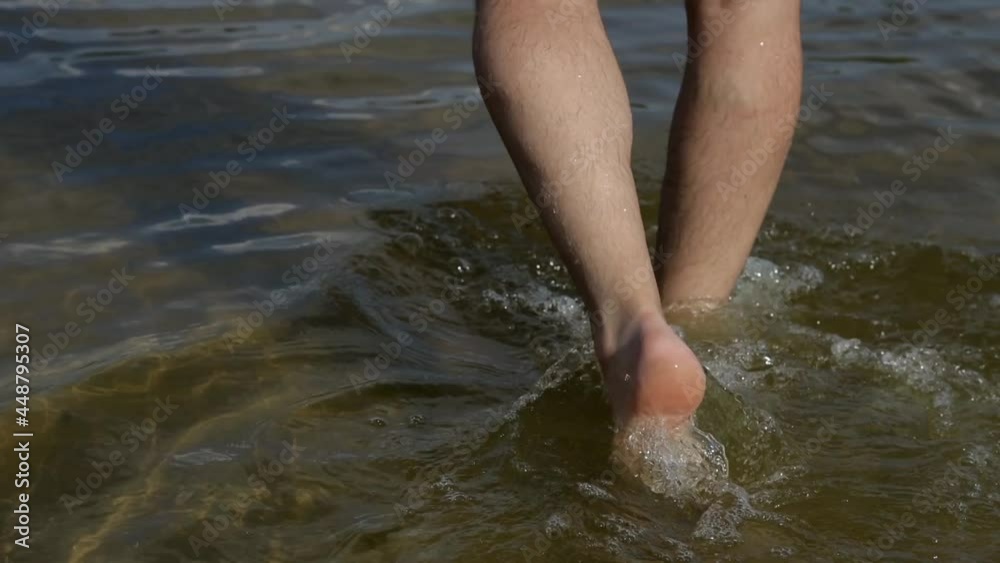 a man walks through the shallow water of a mountain lake. Unity with nature a man walks through the shallow water of a mountain lake. Unity with nature