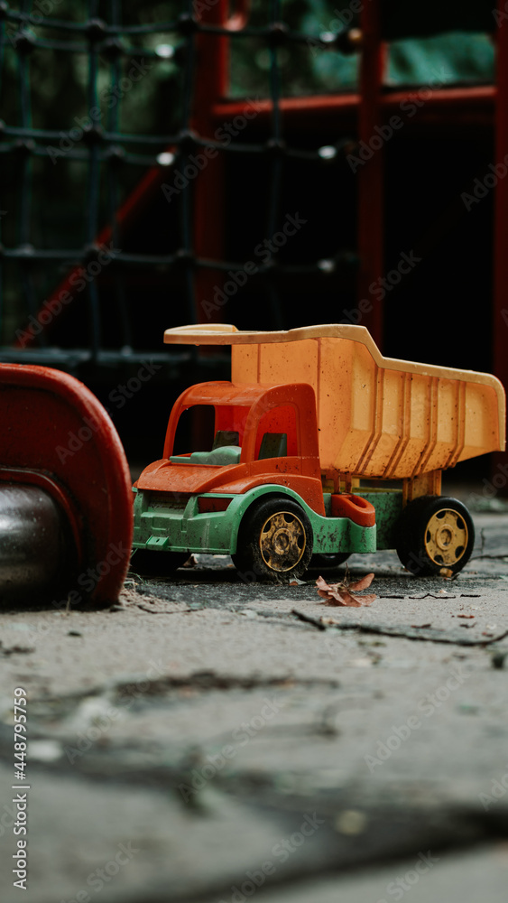 Toy truck on the playground after the rain - obrazy, fototapety, plakaty 