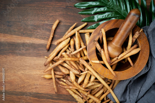 top view fresh finger root or kaempfer (kachai) Thai herb on wooden table and mortar with pestle on the background. copy space. flat lay                                                               photo