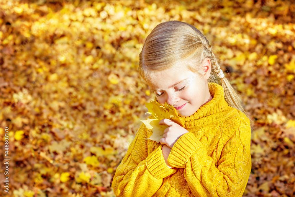 Little girl in autumn forest with yellow maple leaves in her hands. Nice autumn season mood. Little girl in autumn forest with yellow maple leaves in her hands. Nice autumn season mood.