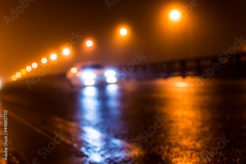 The bright lights of the city at night, the car racing on the road bridge. Defocused image