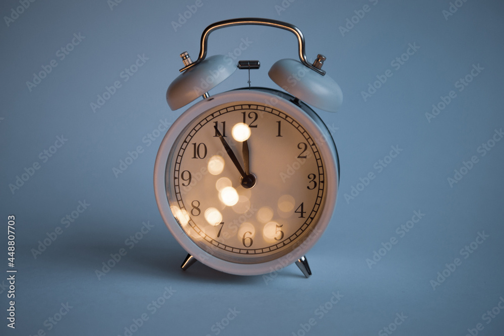 large clock showing 12 o'clock on a uniform blue background with place for text christmas theme. High quality photo large clock showing 12 o'clock on a uniform blue background with place for text christmas theme. High quality photo