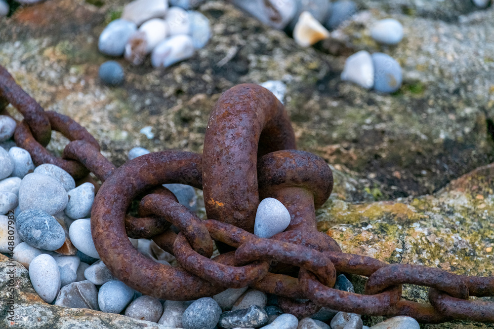 Fragment of old anchor chain on stone background. Marine theme and style. High quality photo Fragment of old anchor chain on stone background. Marine theme and style. High quality photo