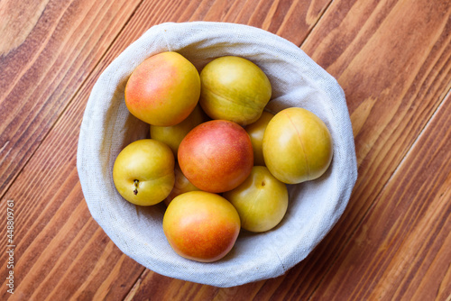 Mirabelle Plums in a basket on a wooden table. Top View