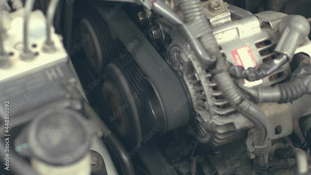 Starting the car's engine by focusing on the rotating engine belt. see the operation of the air compressor starter and engine