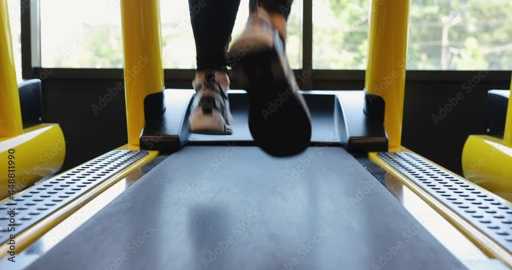 Legs running on treadmill in a fitness center, slow motion Legs running on treadmill in a fitness center, slow motion