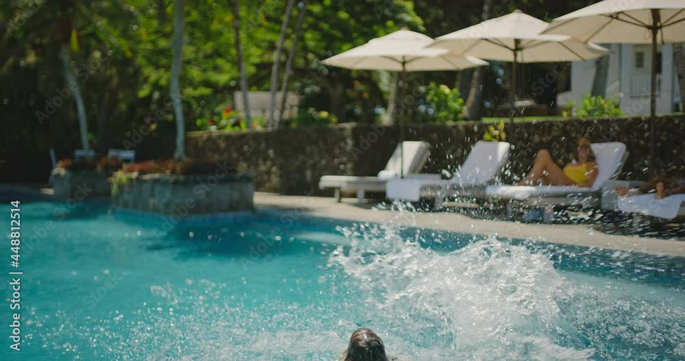 Kids jumping into the pool, family lifestyle, playing at the pool on summer vacation