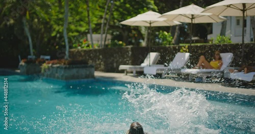 Kids jumping into the pool, family lifestyle, playing at the pool on summer vacation