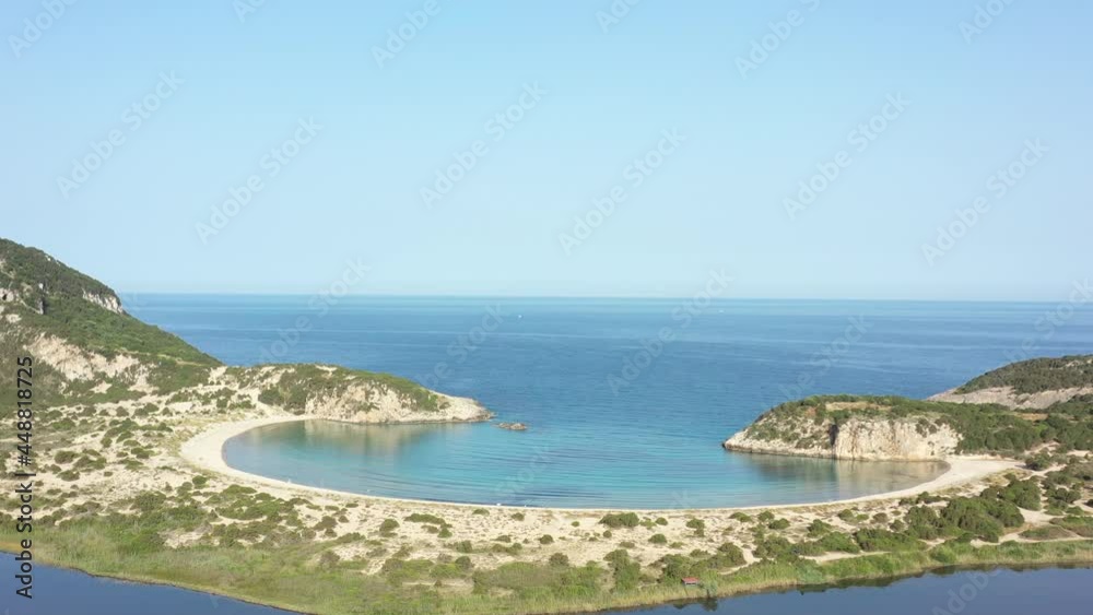 Aerial drone video of semicircular sandy beach and lagoon of Voidokilia, one of the most iconic beaches in Mediterranean sea, with crystal clear turquoise sea, Messinia, Greece Aerial drone video of semicircular sandy beach and lagoon of Voidokilia, one of the most iconic beaches in Mediterranean sea, with crystal clear turquoise sea, Messinia, Greece