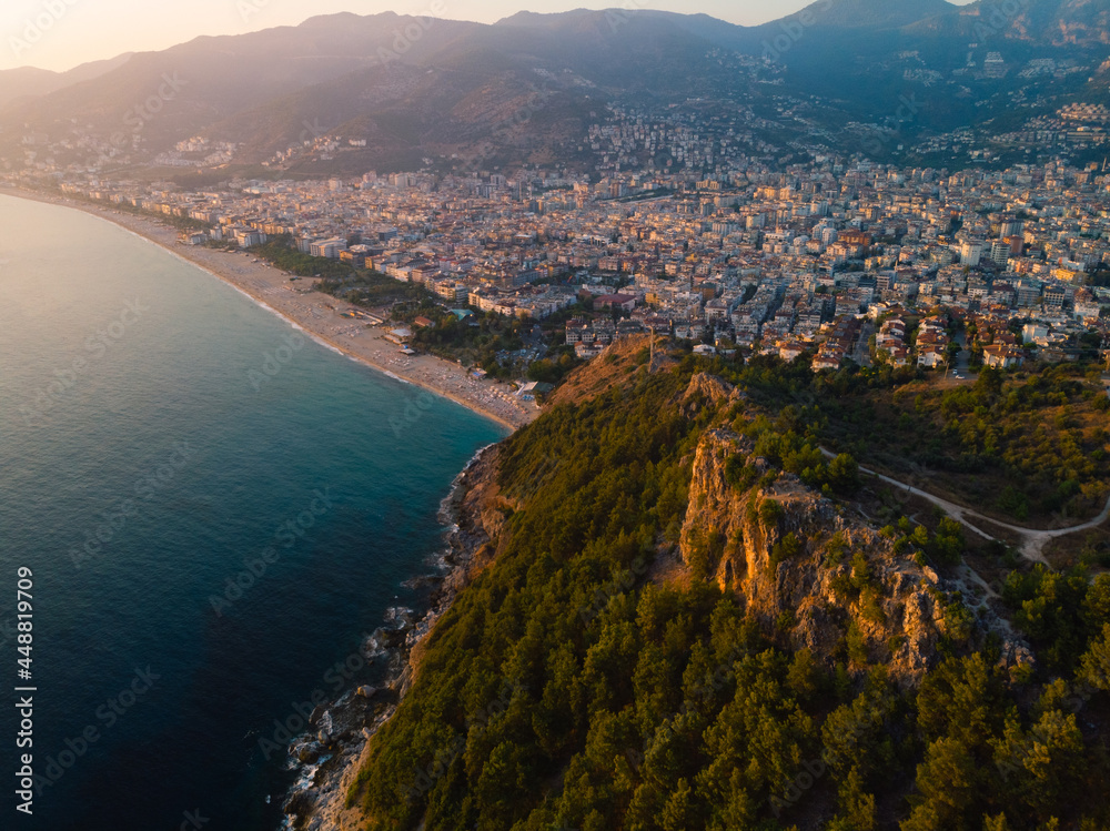Aerial view resort city Alanya in southern coast of Turkey, Summer day. Travel and vacation. Kalesi Castle. Mountain. Ships and boats in the mediterranean