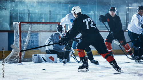 Ice Hockey Rink Arena: Professional Forward Player Breaks Defense, Hitting Puck with Stick to Score a Goal. Game Near Gate or Goal. Important and Tension Moment in Sport Full of Emotions.