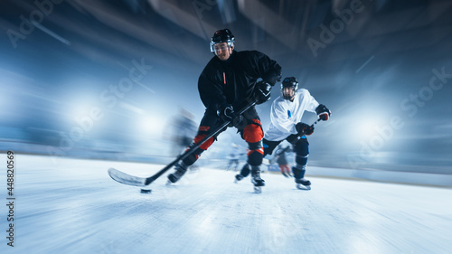Ice Hockey Rink Arena: Professional Forward Player Masterfully Dribbles, Breaks Defense and Riding On Camera. Strong Performance Teams Play. Blurred motion Shot.