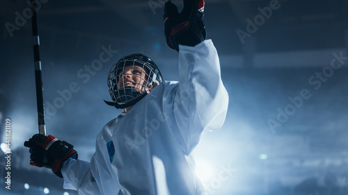 Professional Ice Hockey Player Celebrating Victory, Raising Arms. photo