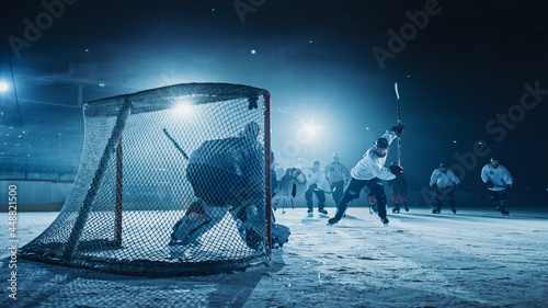 Ice Hockey Game in Rink Arena: Forward Player who Does Slapshot, Shoots Puck with Stick, Goalie Catches the Puck. Dramatic Moment Forwarder against Goalkeeper.