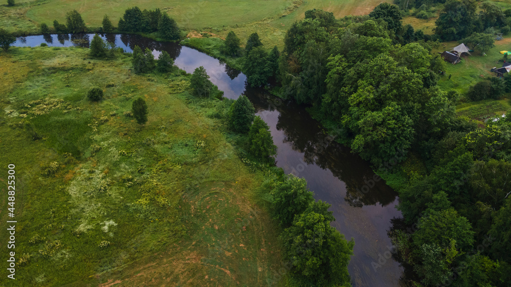 Aerial landscape of winding river in green field, top view of beautiful nature background from drone, seasonal summer landscape with copy space. Aerial landscape of winding river in green field, top view of beautiful nature background from drone, seasonal summer landscape with copy space.