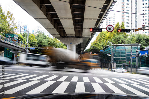 Vehicles passing through an intersection under an overpass