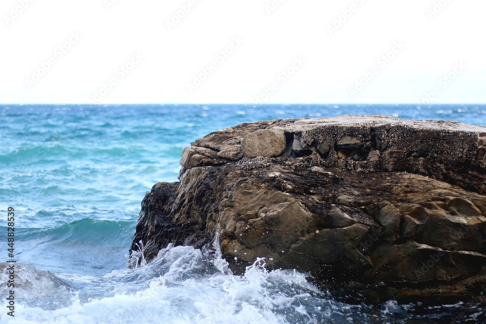 Rocks and waves on a beach. Selective focus. Rocks and waves on a beach. Selective focus.