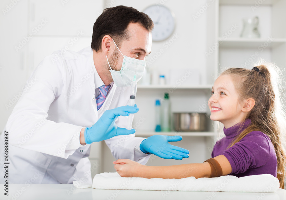 Fototapeta premium Adult doctor ready to make injection to teenage female visitor in hospital