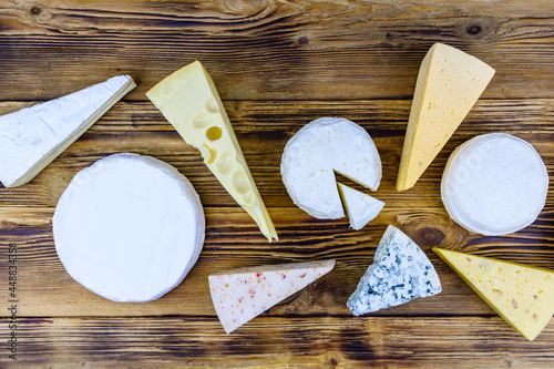 Various types of cheese on a wooden background. Top view