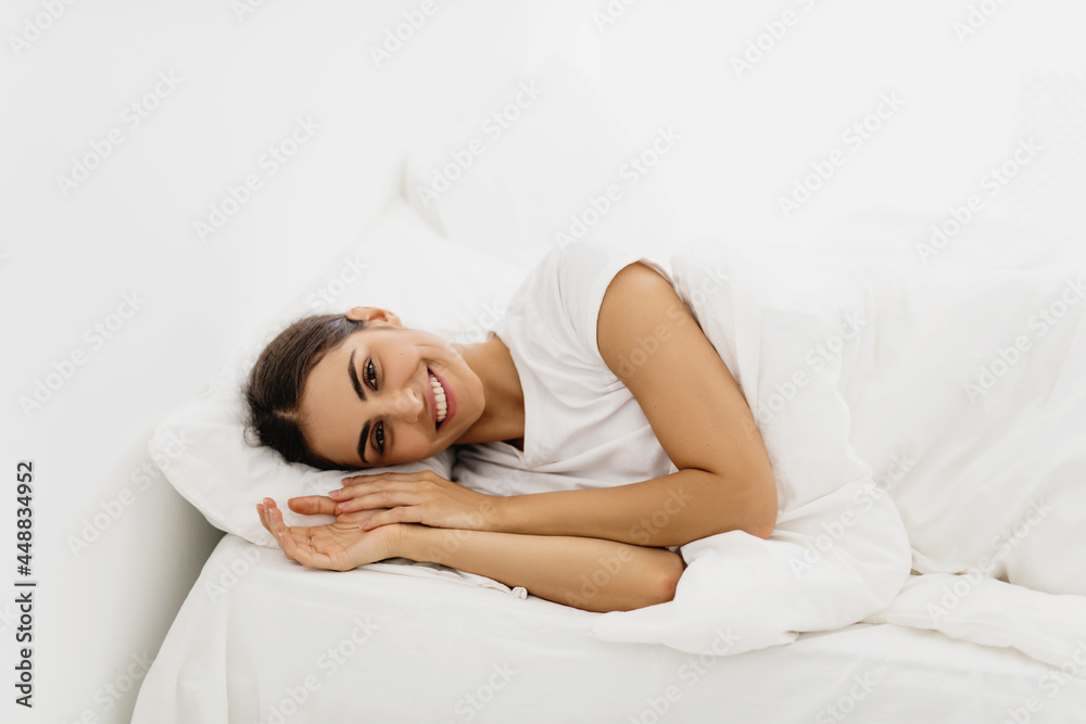 Young beautiful smiling brunette woman waking up on bed. Young beautiful smiling brunette woman waking up on bed.